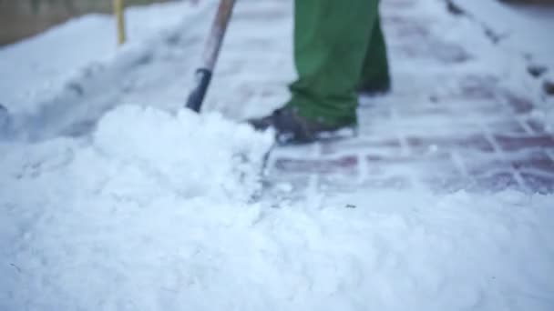 敷石から積雪を除去するエリアホスト 作業服の労働者は 凍結雪の都市の不動産の領域をクリアします — ストック動画