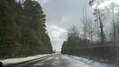 Arabanın ön camından dışarı bak. Aracın sürdüğü asfalt şeritli birikmiş bir yol. Yol karla dolu..