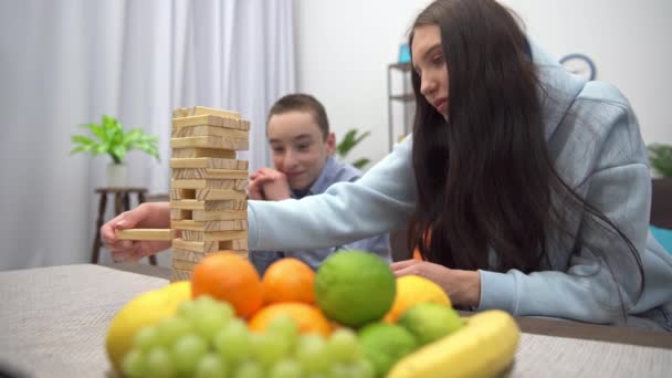 ティーンエイジャーと大人のための最高のゲーム 木製のブロックの塔 妹と弟は一緒に一つのゲームをプレイ — ストック動画