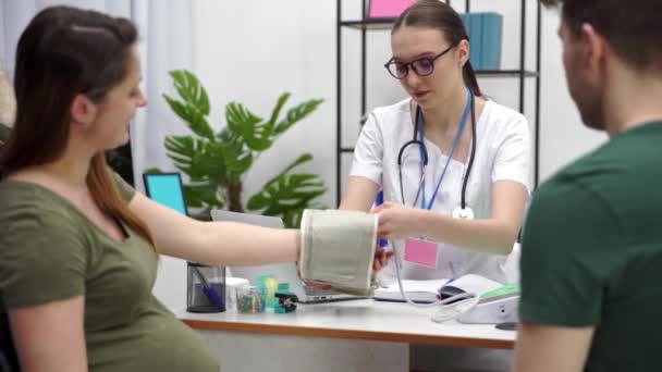 신중에 의사들을 방문한다 임신부의 혈압을 검사한다 — 비디오