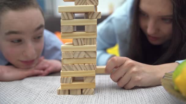 Nahaufnahme Eines Turms Aus Holzklötzen Geschwister Spielen Gemeinsam Ein Arcade — Stockvideo