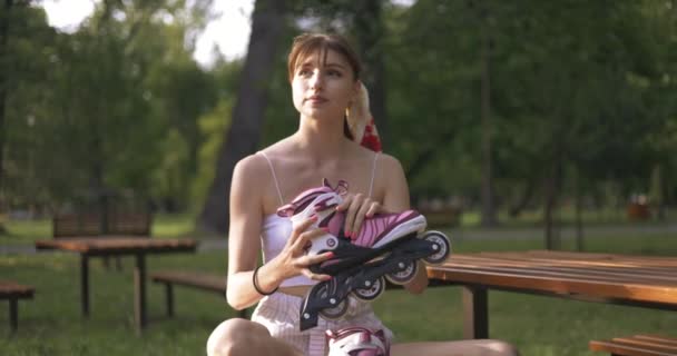 Młoda Dziewczyna Siedzi Skrzyżowanymi Nogami Ławce Parku Dziewczyna Odwraca Głowę — Wideo stockowe