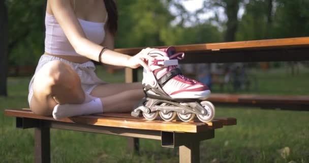 Κορίτσι Κάθεται Στο Πάρκο Ένα Παγκάκι Σταυρωμένα Πόδια Είναι Ντυμένη — Αρχείο Βίντεο