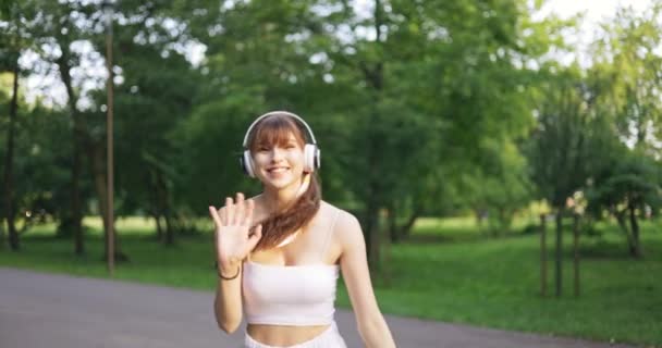 Κορίτσι Στο Πάρκο Γυρίζει Μπροστά Και Χαμογελάει Χαιρετώντας Χαλαρώνοντας Στη — Αρχείο Βίντεο