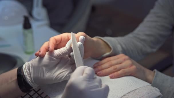 一个女人正在美容院修指甲 美容师使用了一个文件 示范钉钉的存放方法 专业人士会剪掉客户的指甲 — 图库视频影像