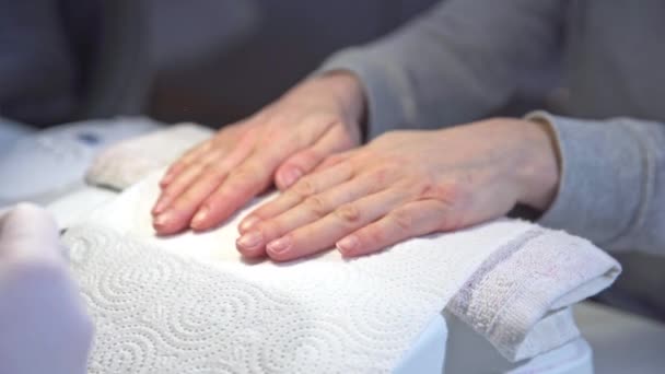 Een Vrouw Een Schoonheidssalon Houdt Haar Handen Een Papieren Handdoek — Stockvideo