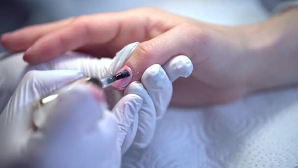 美甲师完成一个顶部清晰的混合美甲 一名接受美容院服务的妇女的手部特写 用一次性氮肥手套工作 — 图库视频影像