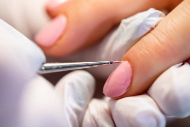 Güzellik uzmanları müşterilerinin tırnaklarına melez cilası sürerler. Profesyonel müşteri hizmetleri. Güzellik salonunda tam bir oje. Tırnak tabağıyla ilgileniyorum..