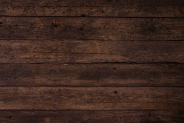 Yatay olarak yığılmış birkaç eski tahta, kahverengi renkli kıyafetler. Doğal malzemelerin arka planı biraz yırtık pırtık..