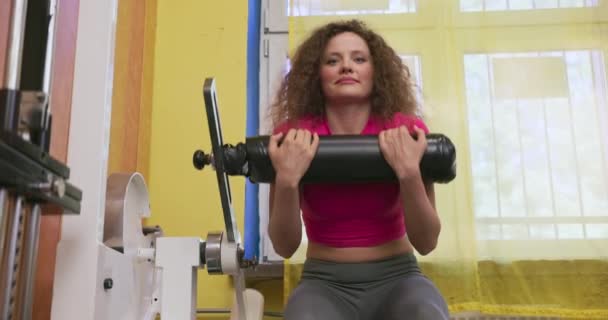 一名女运动员在专用设备上做弯腰运动 体操馆的剧烈运动 — 图库视频影像