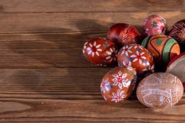 Eski kahverengi tahtalara yerleştirilmiş birkaç Paskalya yumurtasının paskalya kompozisyonu. Yazı eklemek için boş kase.