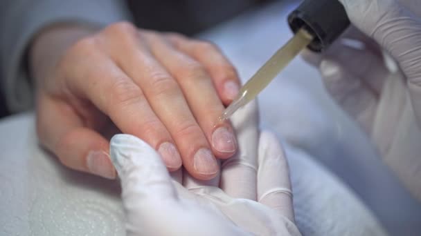 一个女人的手的特写 一个女人使用一个专业的美容院的服务 雇员戴着一次性手套 在顾客的小颗粒上涂上油 — 图库视频影像