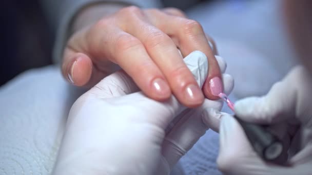 美容师画女人的指甲 一个女人利用美容院的服务 有修指甲的女人的手的特写 用粉红抛光漆钉 — 图库视频影像