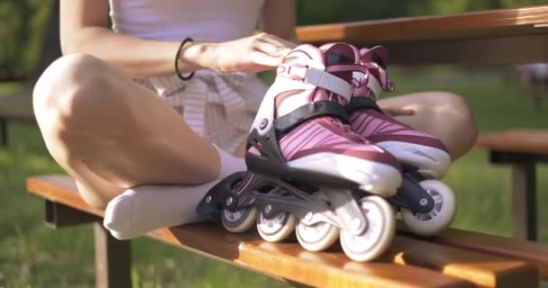 Девушка Сидит Скамейке Парке Скрещенными Ногами Держит Перед Собой Пару — стоковое видео