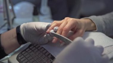 Bir müşteri güzellik salonunun hizmetlerinden faydalanıyor. Tırnak bakımı yapıyorum. Güzellik salonunda modern ekipmanlar. İşlem sırasında hijyen ilkelerinin korunması.