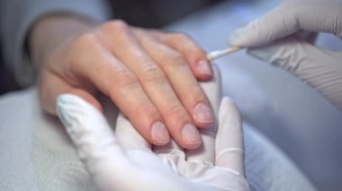 Profesyonel bir güzellik salonuna bir ziyaret. Nitelikli bir çalışan tarafından el bakımı. Tırnakları beslemek ve tırnakları diğer tedaviler için hazırlamak..