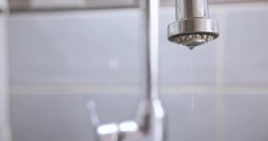 Kırık bir metal musluktan su damlıyor. Damlayan bir musluktan düşen su damlaları..