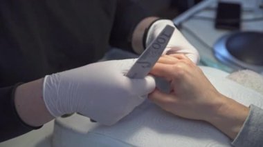 Tırnak kesen bir manikürcünün ellerine yakın çekim. Güzellik salonu müşterisi güzellik tedavisi görüyor. Modern güzellik salonu ekipmanları
