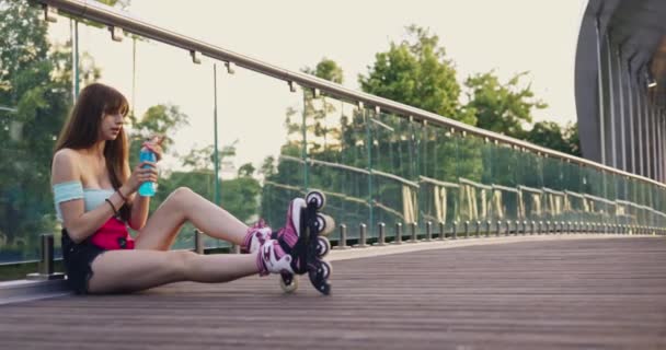 Uma Rapariga Patinadora Usar Lâminas Patins Menina Senta Uma Ponte — Vídeo de Stock