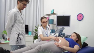 Ultrasondan sonra hemşire hamile kadınların karnını kalın bir jelle kurutur. Hamilelik sırasındaki periyodik fetal gözlemin sonu.