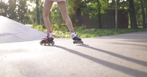 公園でスケートをしながらスピンを作る方法を学ぶ ローラースケートをしながら女の子が回転します 適切な機器とスポーツウェアで屋外スポーツをプレイ — ストック動画