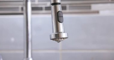 Banyodaki sızdıran musluktan damlalar düşüyor. Musluktan damlayan su.