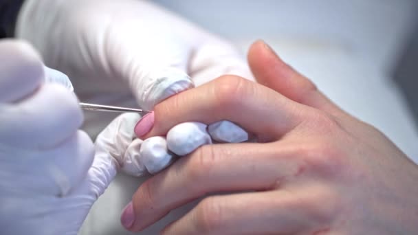 一个女人在美容院接受治疗时的特写镜头 画食指的指甲 用粉红指甲油美容院深层美容美发服务 — 图库视频影像