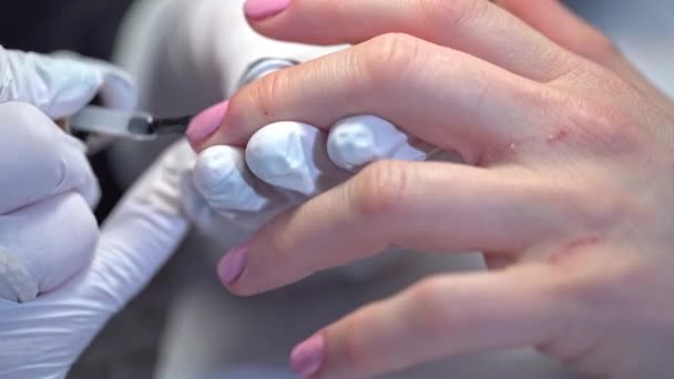 美容院的专业美甲绘画服务 一个美容院客户的特写镜头用粉色指甲油修指甲 美容师用一个清晰的顶盖 — 图库视频影像