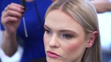 Berber koltuğunda oturan bir kadının yüzüne yakın çekim. Kadın kuaföre nasıl bir saç stili istediğini anlatıyor. Kuaför, müşterinin saçında rol alır. Kuaför...