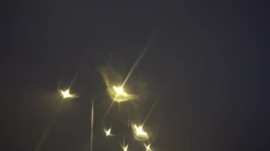 Şoförlerin bakış açısından sokağa bak. Gece vakti şehrin içinden geçerek. Araç yanan sokak lambalarını geçiyor. Sokak lambalarının bulanık ışıklarının görüntüsü. Bir yolcu arabası sürüyorum..