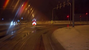 Trafik ışıklarında yeşil ışık yandığında araba çalışır ve sağa döner. Gece araba sürerken. Araba sürücüsünün perspektifinden bak.