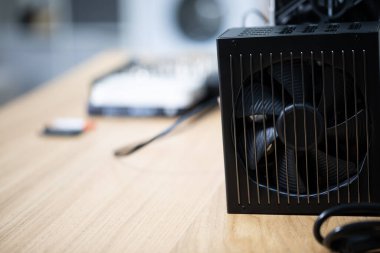 Vantilatörle donatılmış bir ısı yükselticisi. Bilgisayar parçaları masanın üzerinde duruyor. İşlemcinin aktif soğutma sistemi. Performansını artırmak için yeni parçaları bilgisayara bağlıyorum.