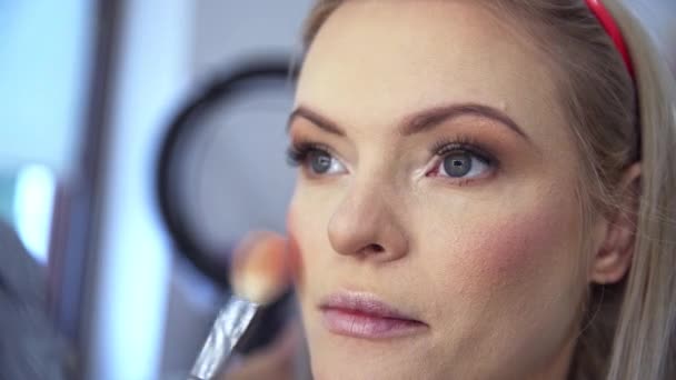 Makijażysta Podkreśla Kości Policzkowe Klientów Nakładanie Makijażu Matującego Przez Kosmetyczkę — Wideo stockowe