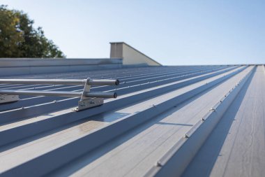 Çatıda kayan kara karşı sistemik koruma. Trapezoidal çarşaflarla kaplanmış, grafit renkli boyalarla kaplı, dik bir çatı..
