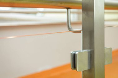 Paslanmaz çelik direğe güçlendirilmiş camın yakın görüntüsü. Camdan yapılmış modern balyoz dolguları..