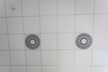 Kare panellerden yapılmış asılmış tavandan ve içine yerleştirilmiş havalandırmadan bak. Yeni tavanları düşürme eğilimi