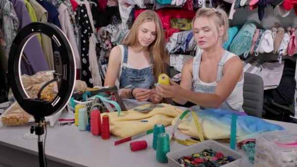 女孩们现场录制Vlog 显示和描述一卷黄色线 为录像准备的缝纫室的设施 — 图库视频影像