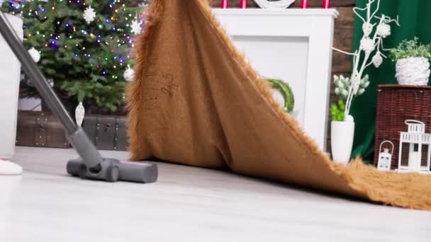 毛むくじゃらのカーペットの下でも部屋全体の徹底的な真空 クリスマスのために装飾されたリビングルーム — ストック動画