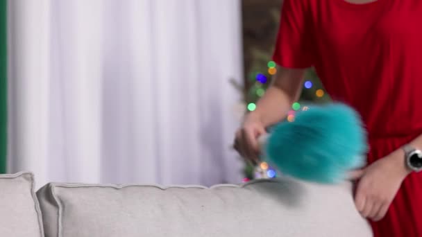 她每天打扫 使整个房子保持整洁 这个女孩用一把特殊的尘灰扫帚扫过沙发的后面 — 图库视频影像