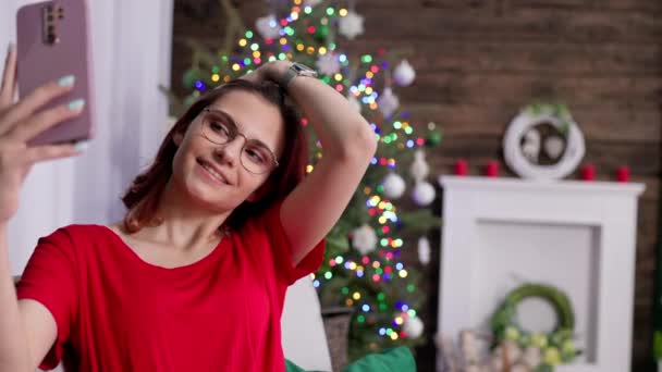 Meisje Rode Jurk Neemt Selfie Tegen Achtergrond Van Kerstboom Met — Stockvideo