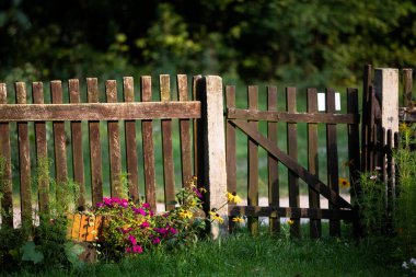 Kırsal eski bir çit, batan güneşin ışınlarıyla yıkanmış. Kırsal manzaralı yaz mevsimi.