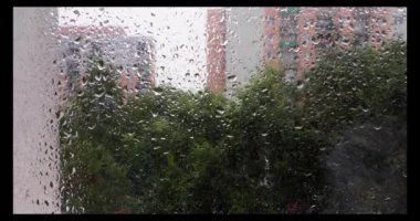 Ön cama sıkışan yağmur damlaları. Yağmurlu hava yağmur mevsiminde su ve nem getirir. Fotografik bokeh efektiyle ön plan bulanıklaştı.