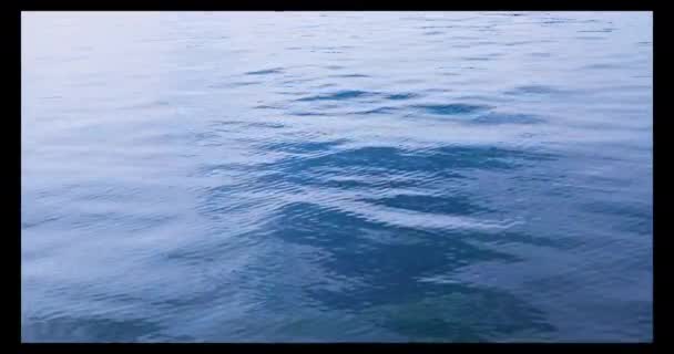 青と白の色合いの湖に水を放っている 遠くから見た水の不透明な波 — ストック動画