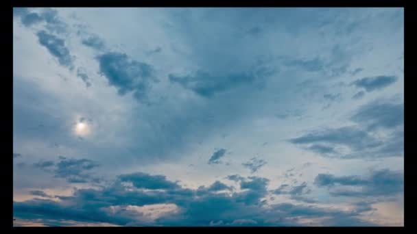 随着时间的流逝 云彩飘扬在天空中 缓慢地向西飞去 在乌云的笼罩下 太阳隐隐约约地照耀着 — 图库视频影像