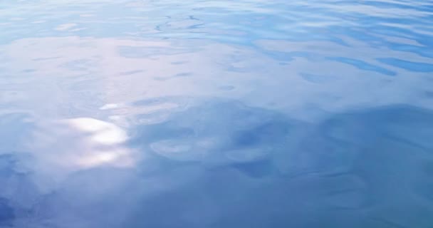 太陽が反射する湖の上に水を流す穏やかな揺れの部分 水面に滑らかな波の上から撮影したフィルム — ストック動画