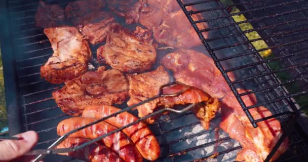 烤架的工作人员用钳子把肉烤到另一边 在露天低温下烤猪肉的艺术 — 图库视频影像
