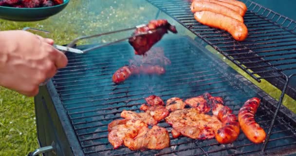 一个男人用钳子从热烤架上取下几片炸得很好的猪肉 度假期间的季节性食物 — 图库视频影像