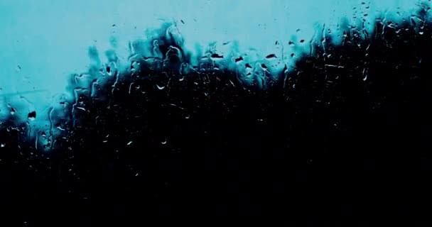 흐리고 비오는 저녁에 시내와 떨어지는 방울은 유리에 있습니다 — 비디오