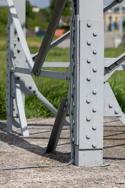 コンクリート基盤の高圧ポールの固定スチールレッグの様子 ボルトで固定された厚い鋼鉄角度 — ストック写真