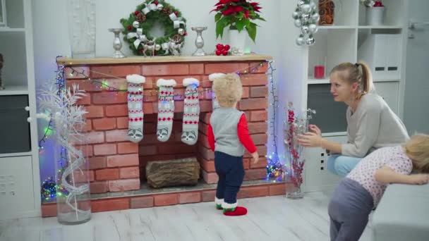 Bir Kadın Iki Küçük Çocuk Noel Süslemeleriyle Dolu Bir Odada — Stok video